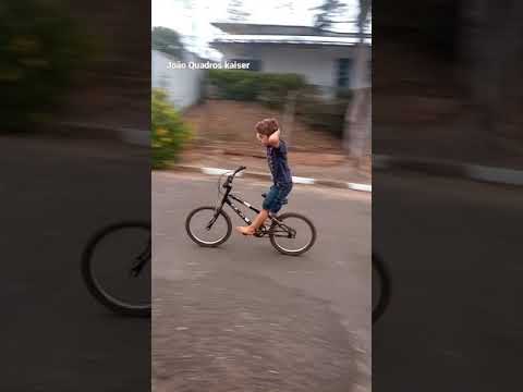 João andando de bike sem as mãos.