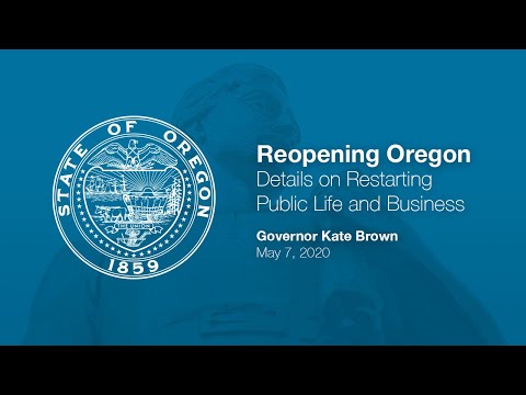 Governor Kate Brown presenting at the June 3rd press conference with a chart and two sign language interpretors in the background