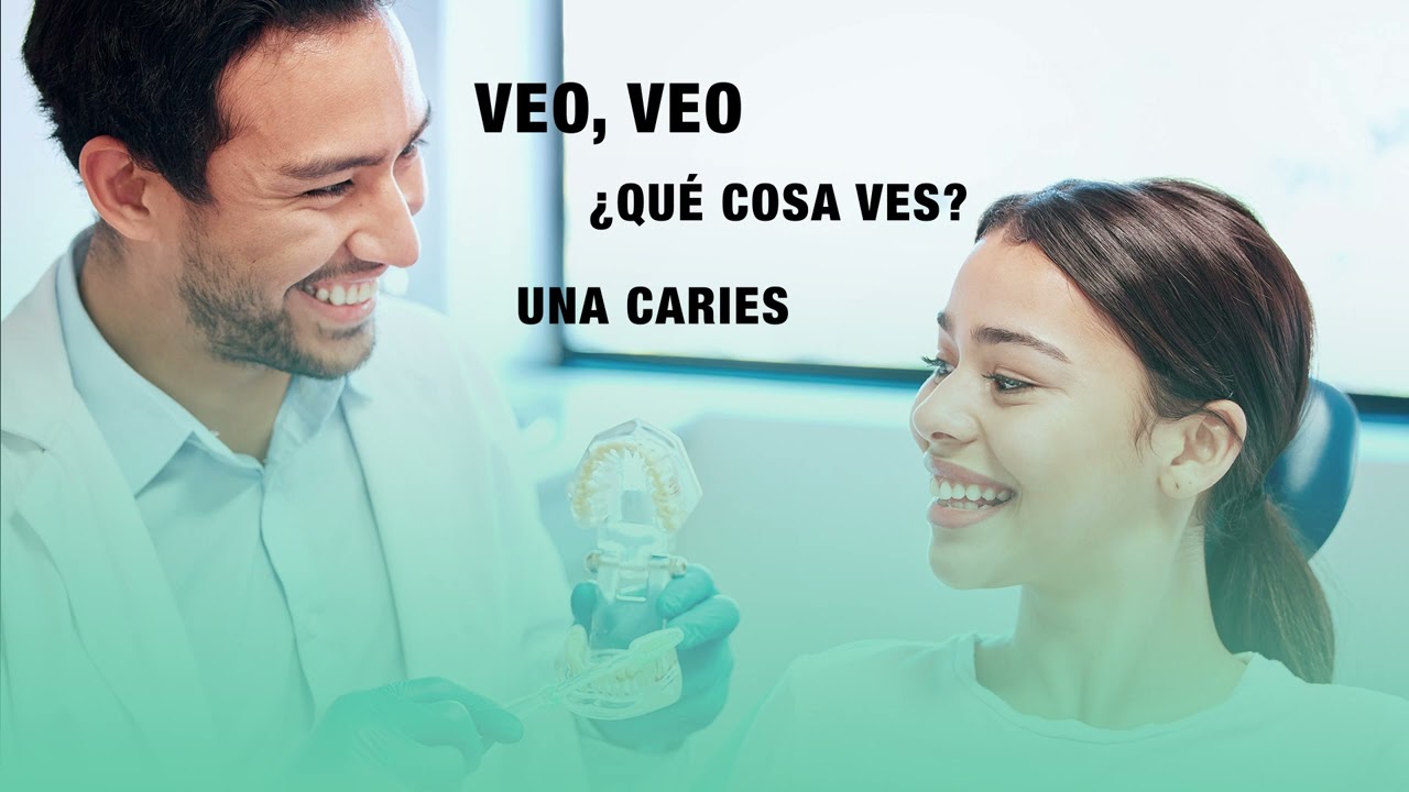 Dentist showing dental model to patient, discussing cavities and aesthetic resin treatments for improved smile at La Clínica Dental.