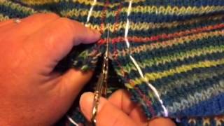 Klipper upp stickningen.