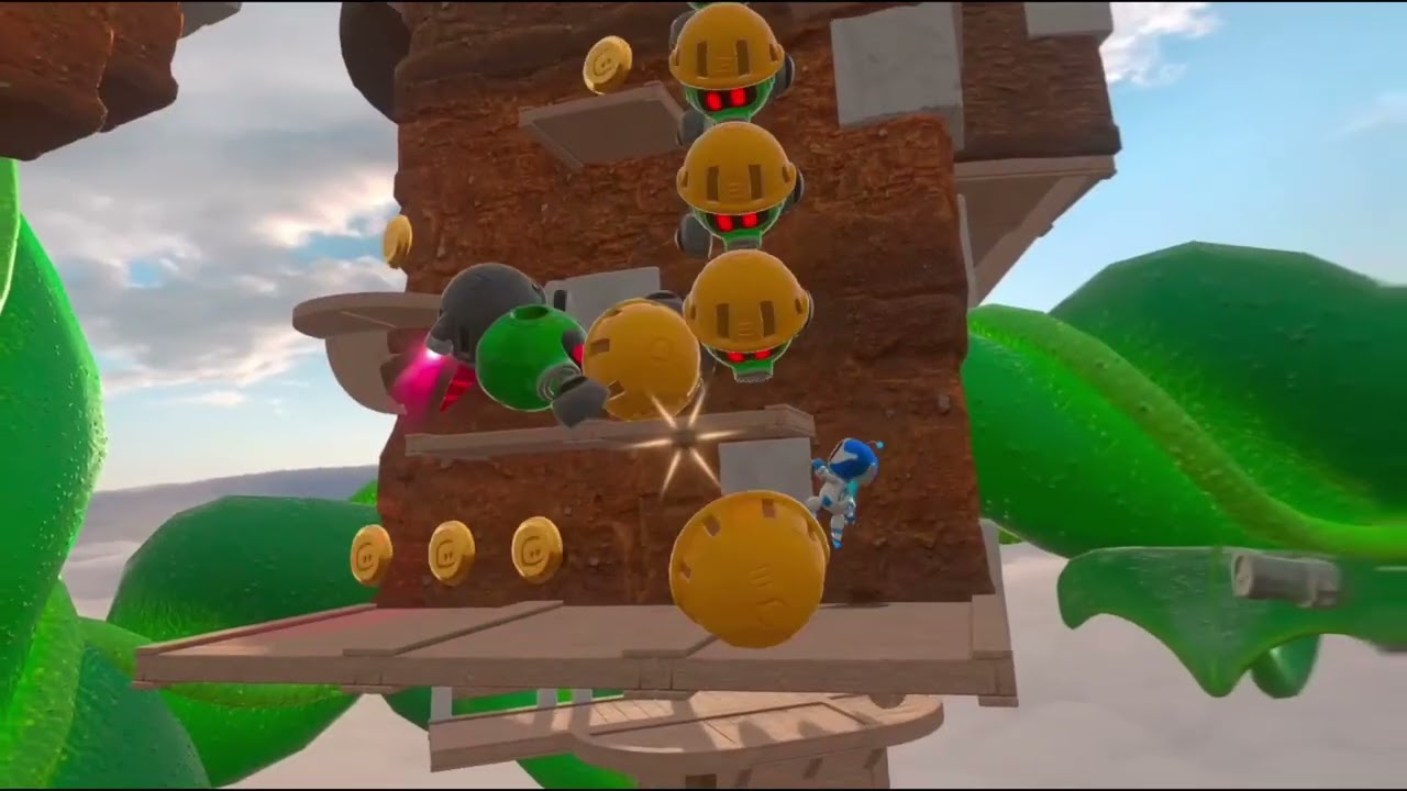 Astro Bot Rescue Mission gameplay: the small white and blue robot Astro climbs a brown rock tower past gold coins and a column of yellow-helmeted enemy robots, with green vines and clouds behind