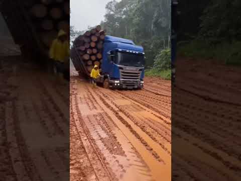 caminhão lotado de toras de madeira quase tomba em estrada ruim e lisa de barro após a chuva
