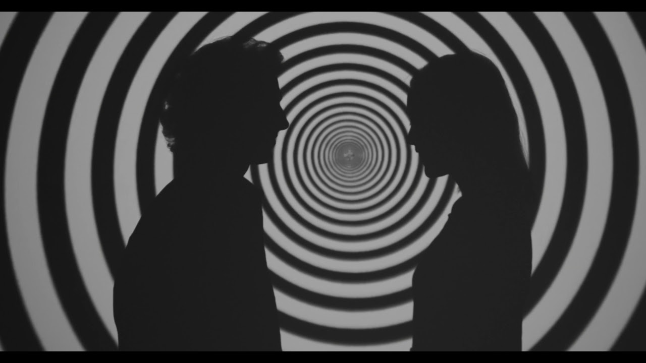 Silhouette of a Man and Woman Facing Each Other in Black and White