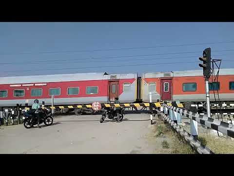 The Red Train thrashes a Level crossing-Indian Railways YPR GKP Exp