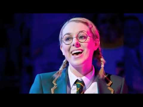 Trailer frame: close-up on vintage mic and guitar during an up-tempo band number