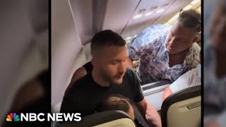 Passengers restrain man accused of trying to enter cockpit mid-flight