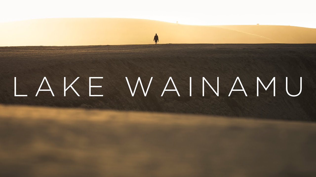 Explore Lake Wainamu Track, a scenic blend of lakes, waterfalls, and sweeping dunes