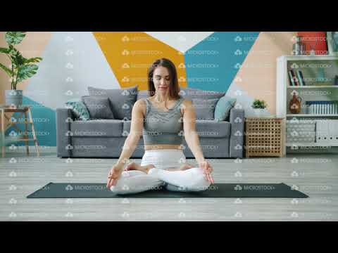 Yoga student doing exercises then relaxing in lotus pose with hands in mudra