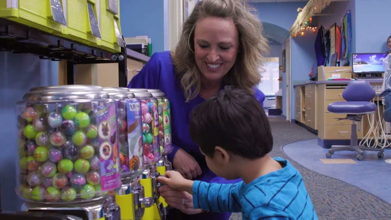 Coppell pediatric dentist helping a child use a gumball machine