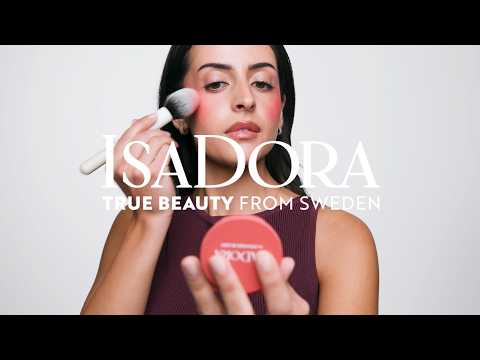 Video där flera IsaDora makeup-produkter som mascara, foundation, bronzer och läpprodukter visas i olika scener mot ren bakgrund. Budskapen “empowering” och “no compromising” förekommer tillsammans med varumärket ISADORA.