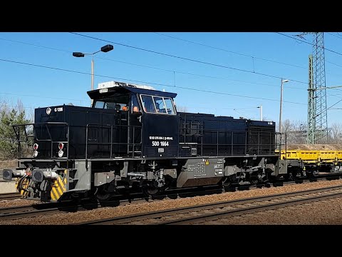 Diesel locomotive BR 276 races with flat cars through the station Berlin-Schönefeld
