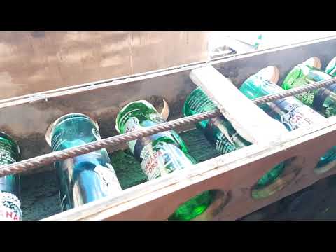 Muro de botellas de vidrio, pircando última fila de botellas.