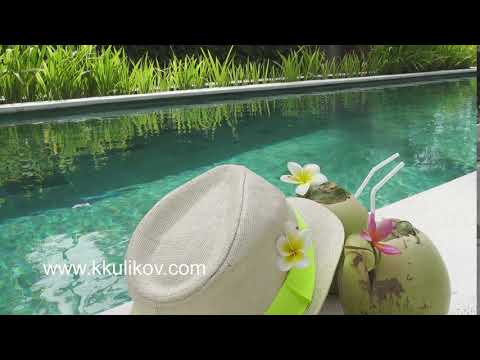 The cocktail in coconut and a straw hat to lie near the pool in the tropical resort
