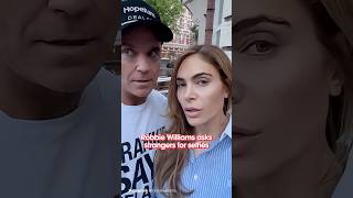 Robbie Williams asks strangers for selfies
