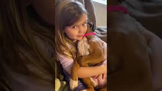 Little girl sings lullaby to puppy