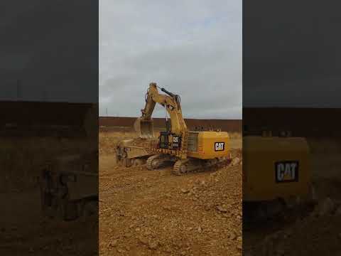 Excavator Caterpillar 6015b loading Dumper Caterpillar 772g in limestone quarry in France