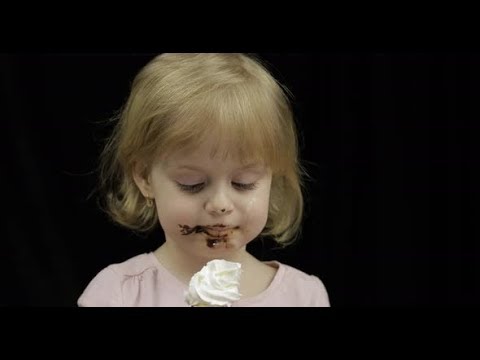 Child with Dirty Face Eats Banana with Melted Chocolate and Whipped Cream | Stock Footage -
