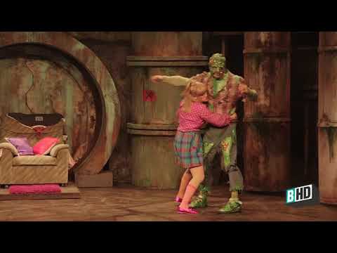 Trailer thumbnail for The Toxic Avenger musical showing Toxie looming over Tromaville in slime-green lighting