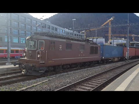 Zug mit Ellok der BLS Re4/4 und Kontainerwagen verlässt den Bahnhof Chur Richtung Landquart, treno