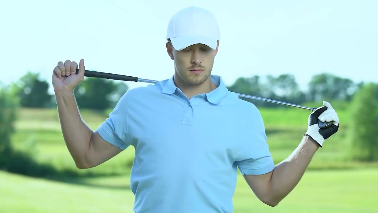 Male golfer holding a club behind his back on a sunny golf course