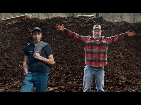 (Family Life) Father and Son working together to spread compost on pasture