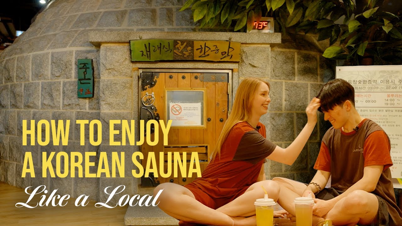Themed sauna room inside a Korean jjimjilbang with traditional earthen walls and people resting on the heated wooden floor