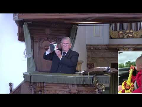 Geëmotioneerde dominee J.C. de Groot laat 'Lofzang van Fleur' aan de kinderen in de kerk zien.