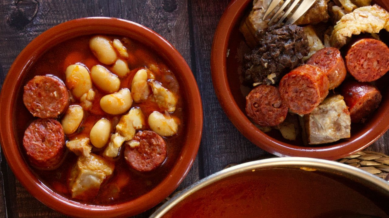 a large pot of Fabada Asturiana is served in an earthenware dish