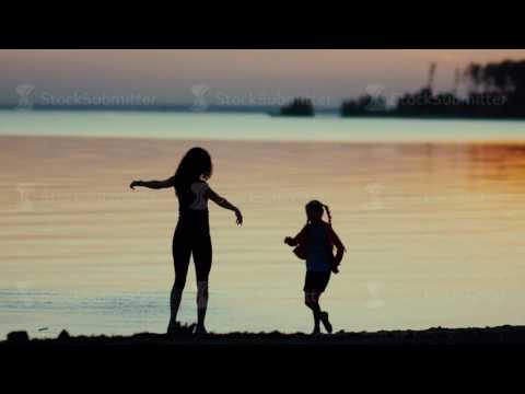 Mom and daughter. Dancing on the beach. Slowmotion