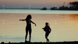 Mom and daughter. Dancing on the beach. Slowmotion
