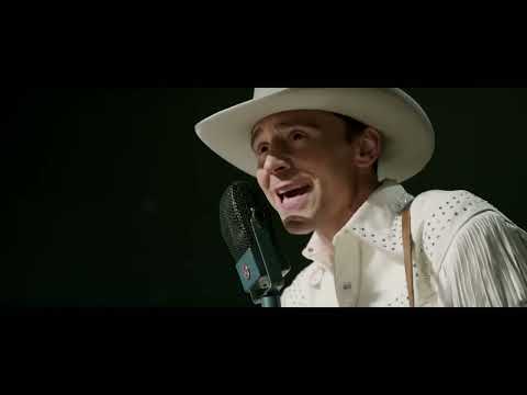 Trailer frame: a lone backlit mic on an empty stage after the crowd has gone