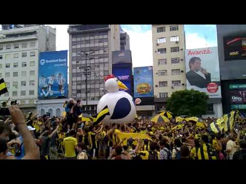 "LA GALLINA GIGANTE EN EL OBELISCO CON LA HINCHADA DEL CARBONERO." Barra: Barra Amsterdam &bull; Club: Peñarol