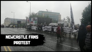 Fans protest in the rain outside of St James' Park