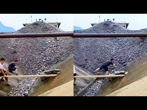 Barge unloading large cobblestone . The cobblestone flow is so satisfying