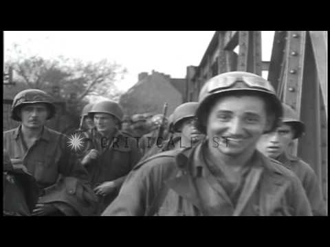 Infantrymen and trucks of US 65th Division cross a bridge and drive in outskirts ...HD Stock Footage