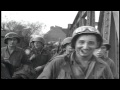 Infantrymen and trucks of US 65th Division cross a bridge and drive in outskirts ...HD Stock Footage
