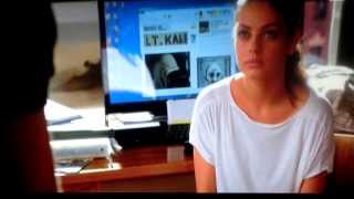 Mila Kunis rubbing her feet on a bed