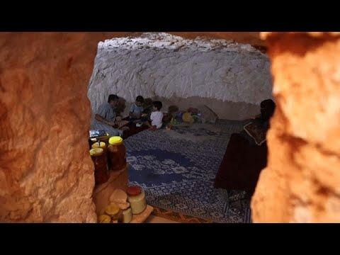 شاهد "أشبه بالقبر".. عائلة سورية تحفر ملجأ في الصخر كملاذ من الغارات…