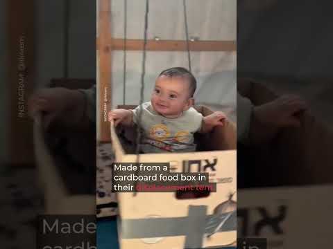 Gaza baby enjoys cardboard swing in displacement tent