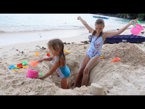 Children playing on the beach with sand and toys 4K 
