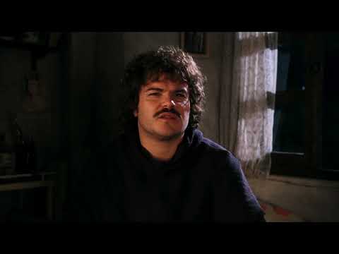Nacho Libre trailer frame with Ignacio in monk robe beside wrestling poster