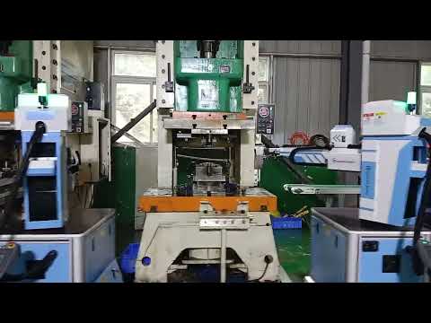 Five 3kg swing-arm manipulators work in tandem with a 200T Yangli press to manage components.