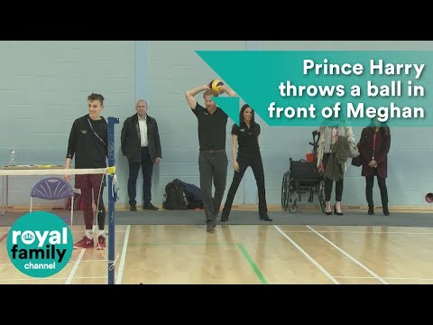 Prince Harry throws a ball in front of Meghan Markle at seated volleyball trials