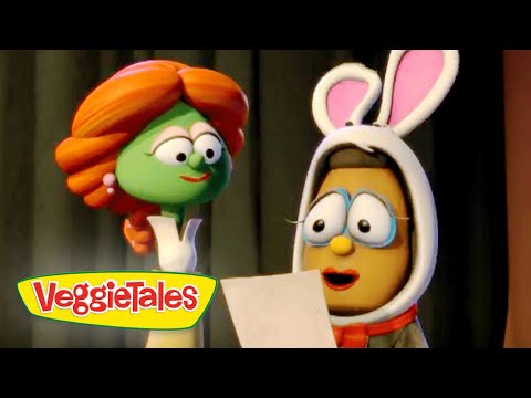Two VeggieTales characters on a stage: a green vegetable with orange hair speaks to a brown character wearing bunny ears, holding a sheet of paper. Logo reads VeggieTales in the corner.