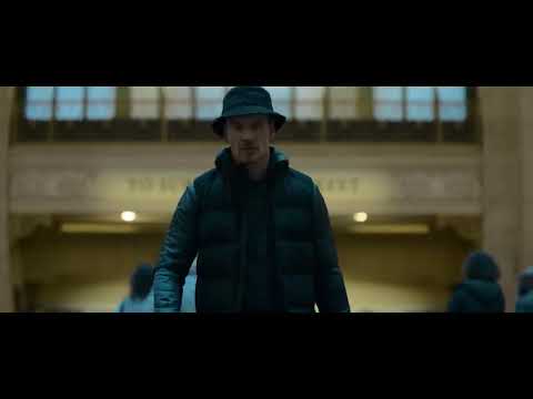 Trailer shot: the Killer on a night street, earbuds in; neon reflections, a low electronic throb implied