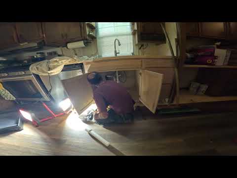 Phil working under a sink for Handy Hands