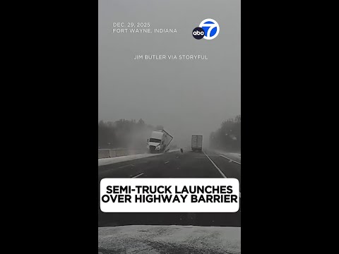 Semi-truck launches over highway barrier