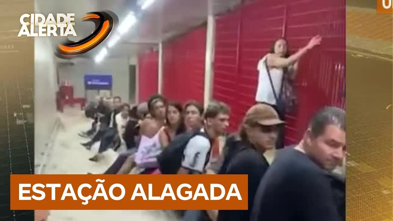 Chuvas alagam estação de metrô em São Paulo, e pessoas se seguram em grade para não serem arrastadas