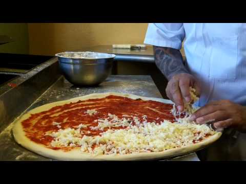 Efrain faz uma pizza no restaurante italiano e pizzaria Mama Romano's