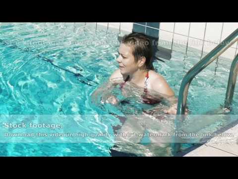 A lady in red bikini walks out of the pool